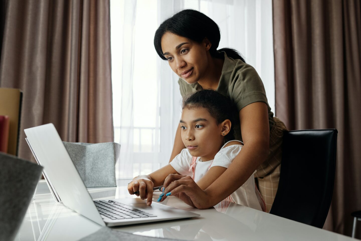 Child and parent work on laptop together